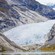 Un glaciar de gran tamaño se abre camino a través de una masa continental rocosa hasta un cuerpo de agua